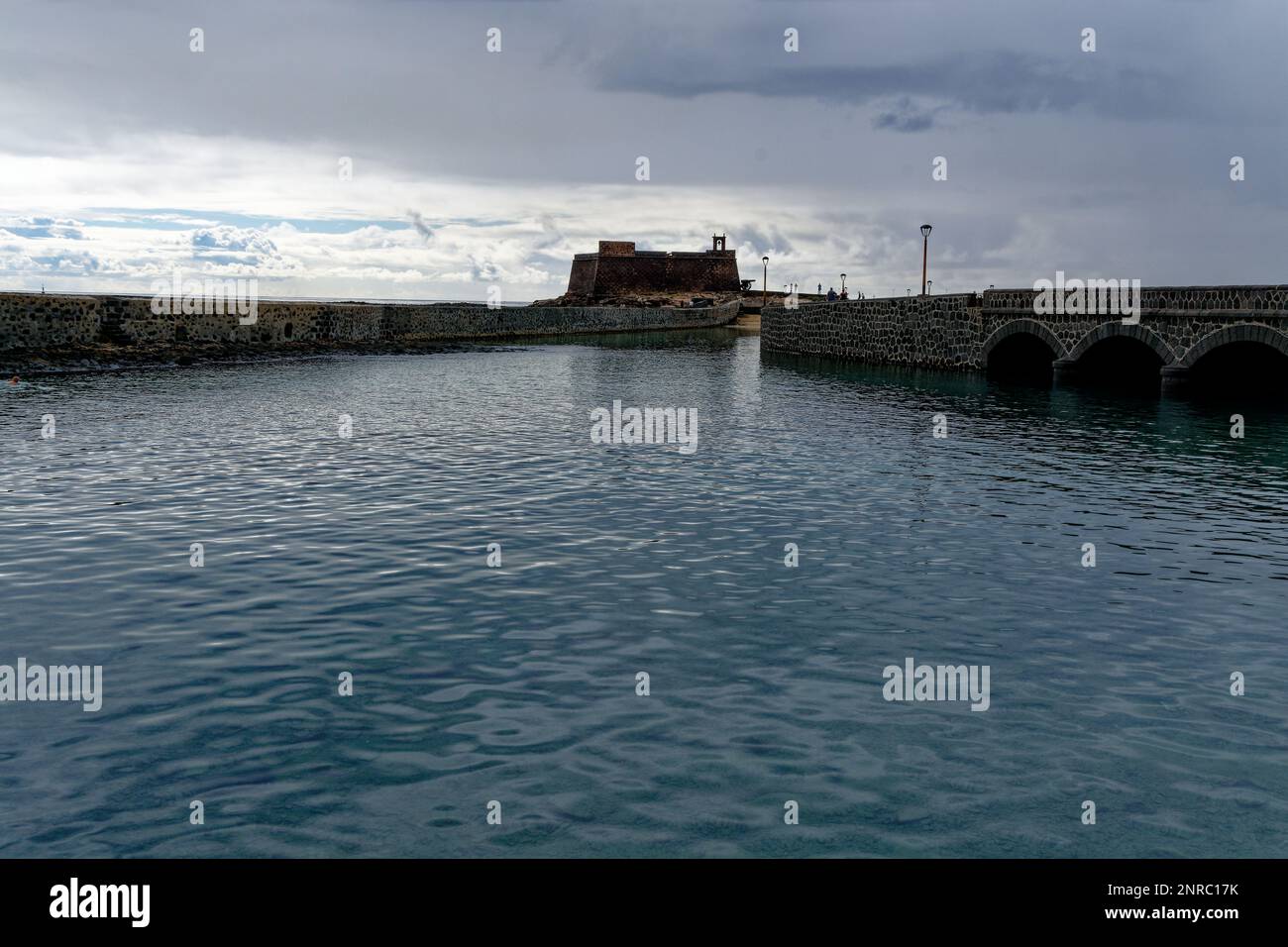 Castillo de San Gabriel in Arrecife, Lanzarote, Canary Islands.. View across the estuary with Puente de las Bolas on left. - Museum Sign on street. Stock Photo