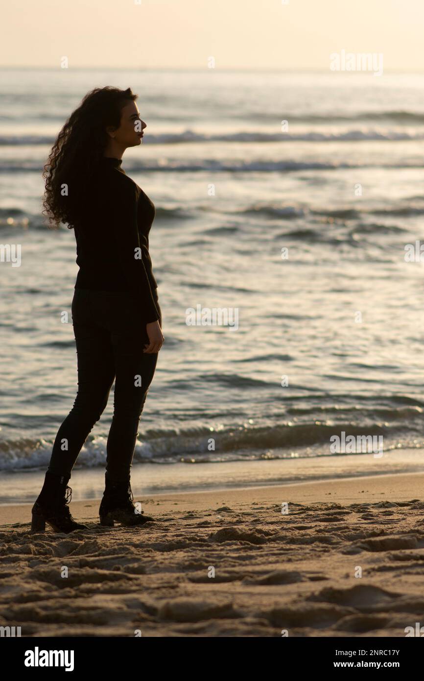 Woman on the beach looking away Stock Photo - Alamy