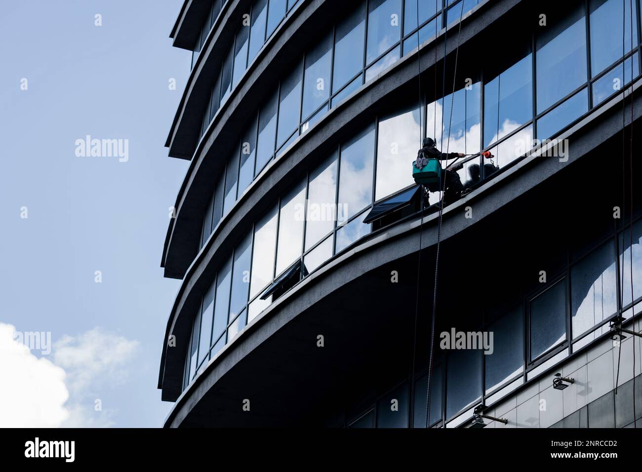 window washer at high altitude washes the facade of a highrise