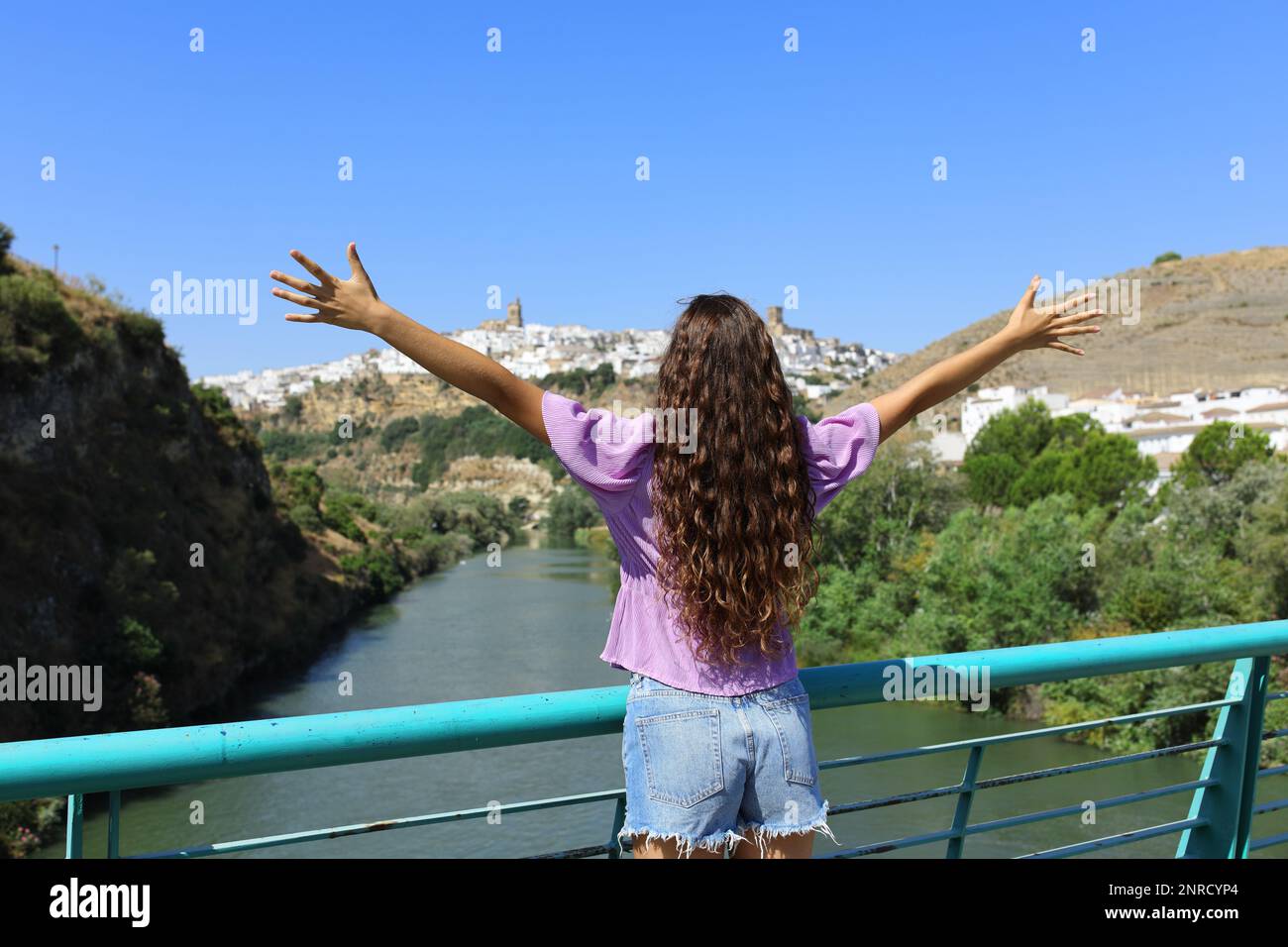 Back view portrait of a tourist celebrating vacation contemplating town views Stock Photo