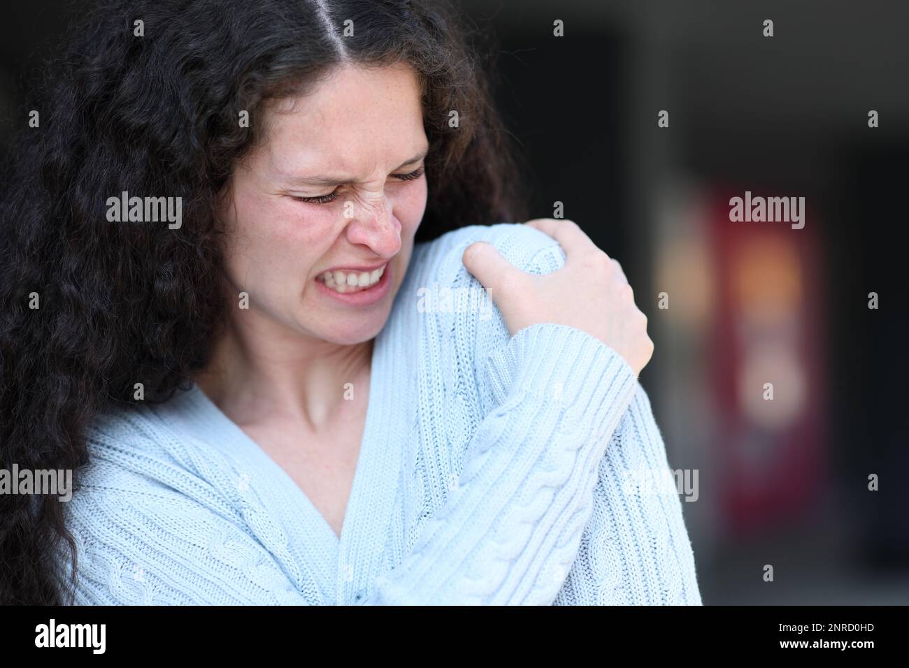 Woman suffering shoulder ache complaining in the street Stock Photo