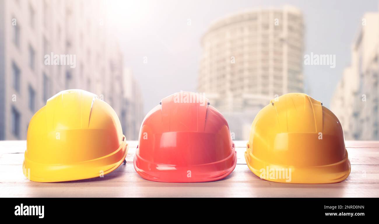 Hard hats on wooden surface at construction site with unfinished