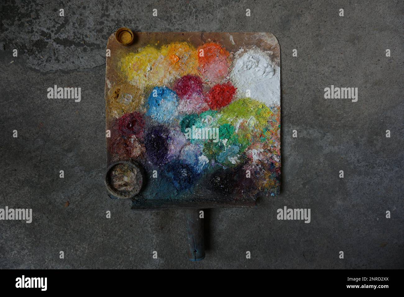 Oil, yellow, green, white, orange mixed together on a palette with