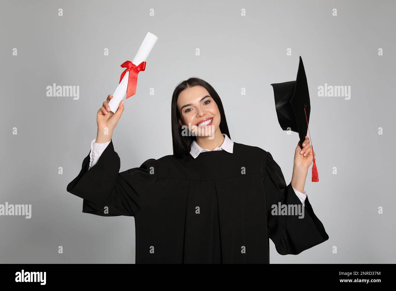 Happy student with graduation hat and diploma on grey background Stock ...