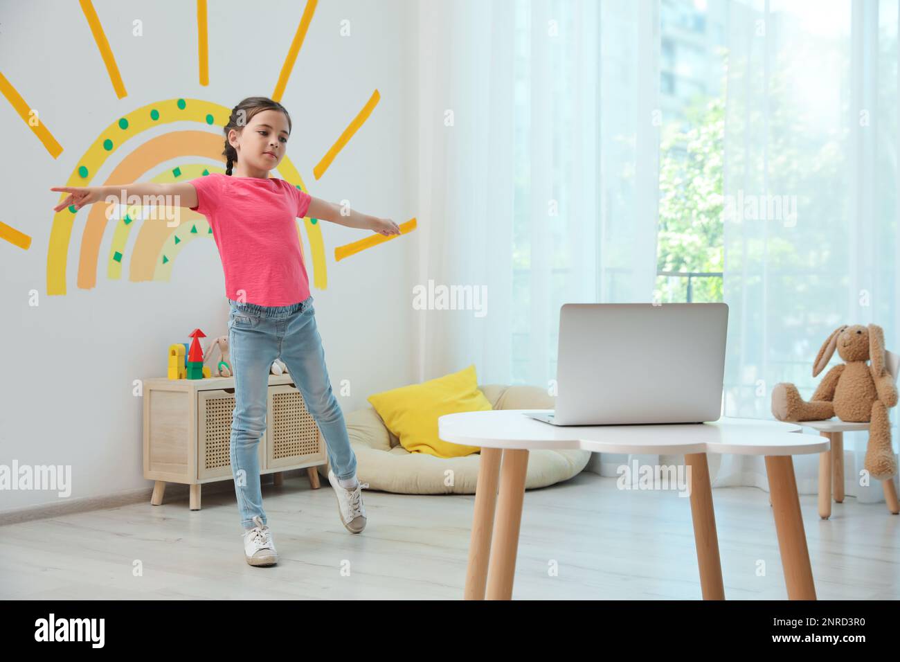 Cute little girl taking online dance class at home Stock Photo - Alamy