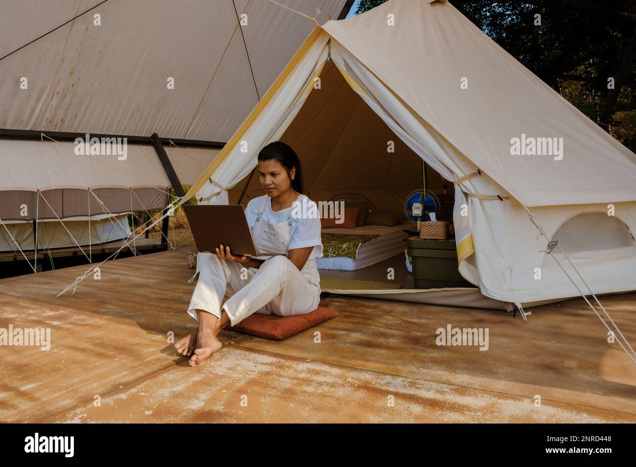 Young Asian woman freelancer traveler working online using a laptop and ...