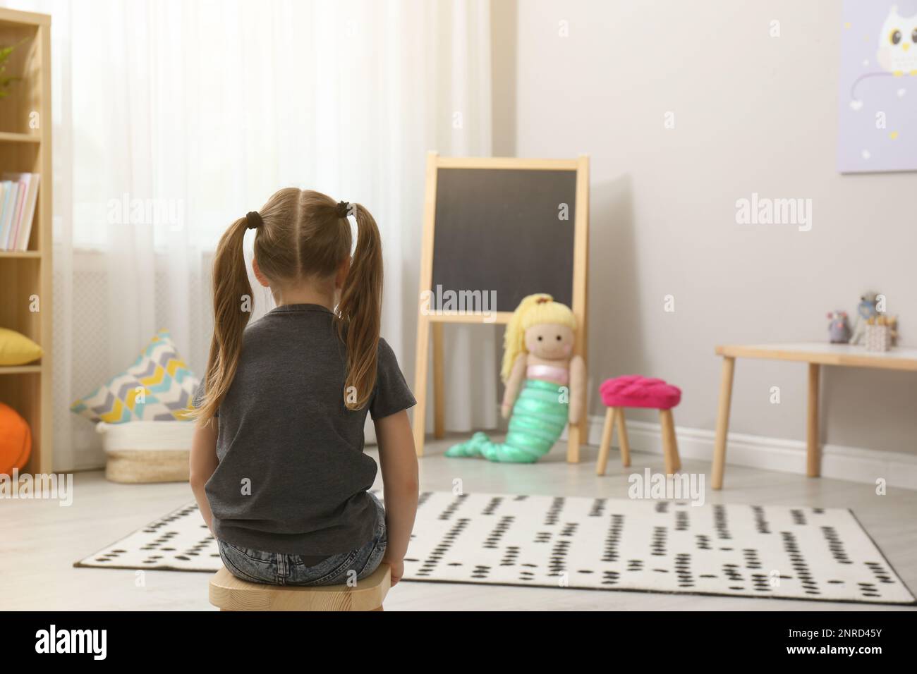 Lonely little girl at home, back view. Autism concept Stock Photo - Alamy