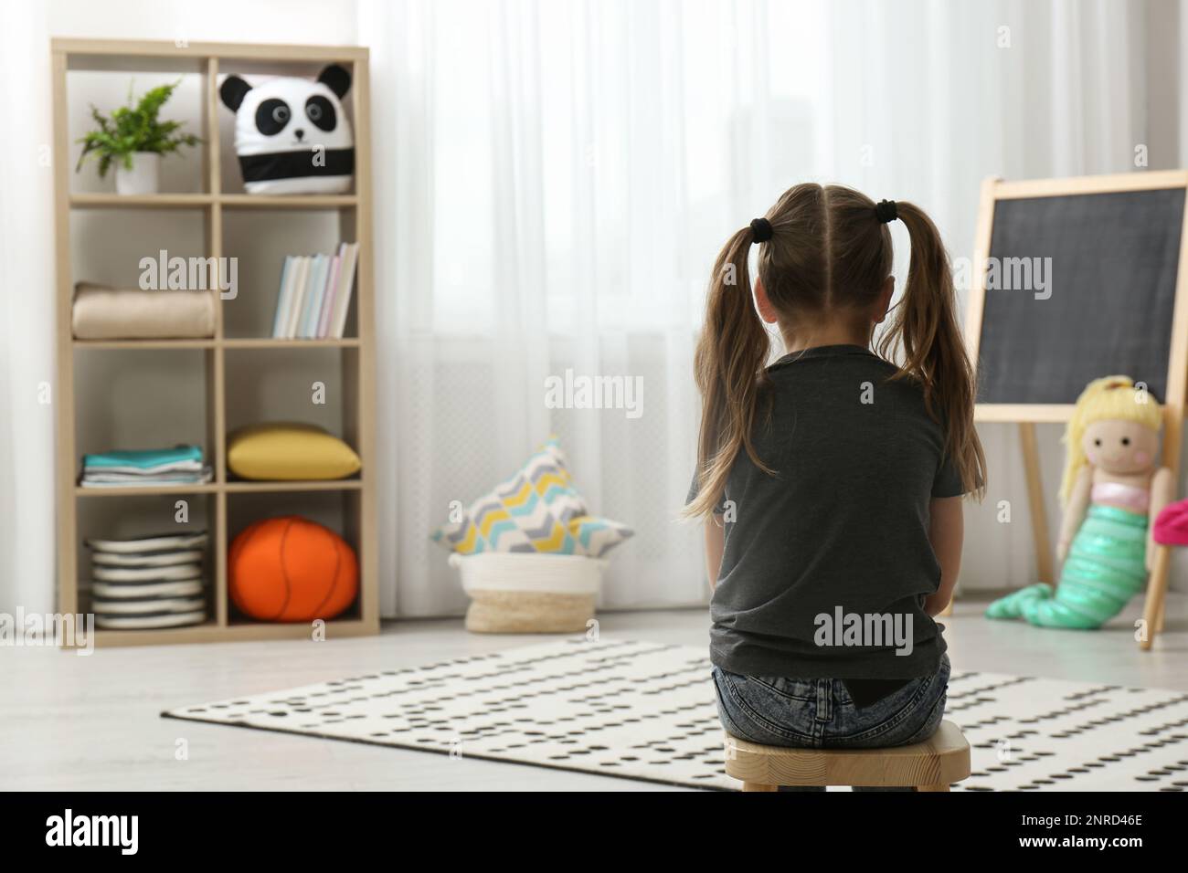 Lonely little girl at home, back view. Autism concept Stock Photo - Alamy