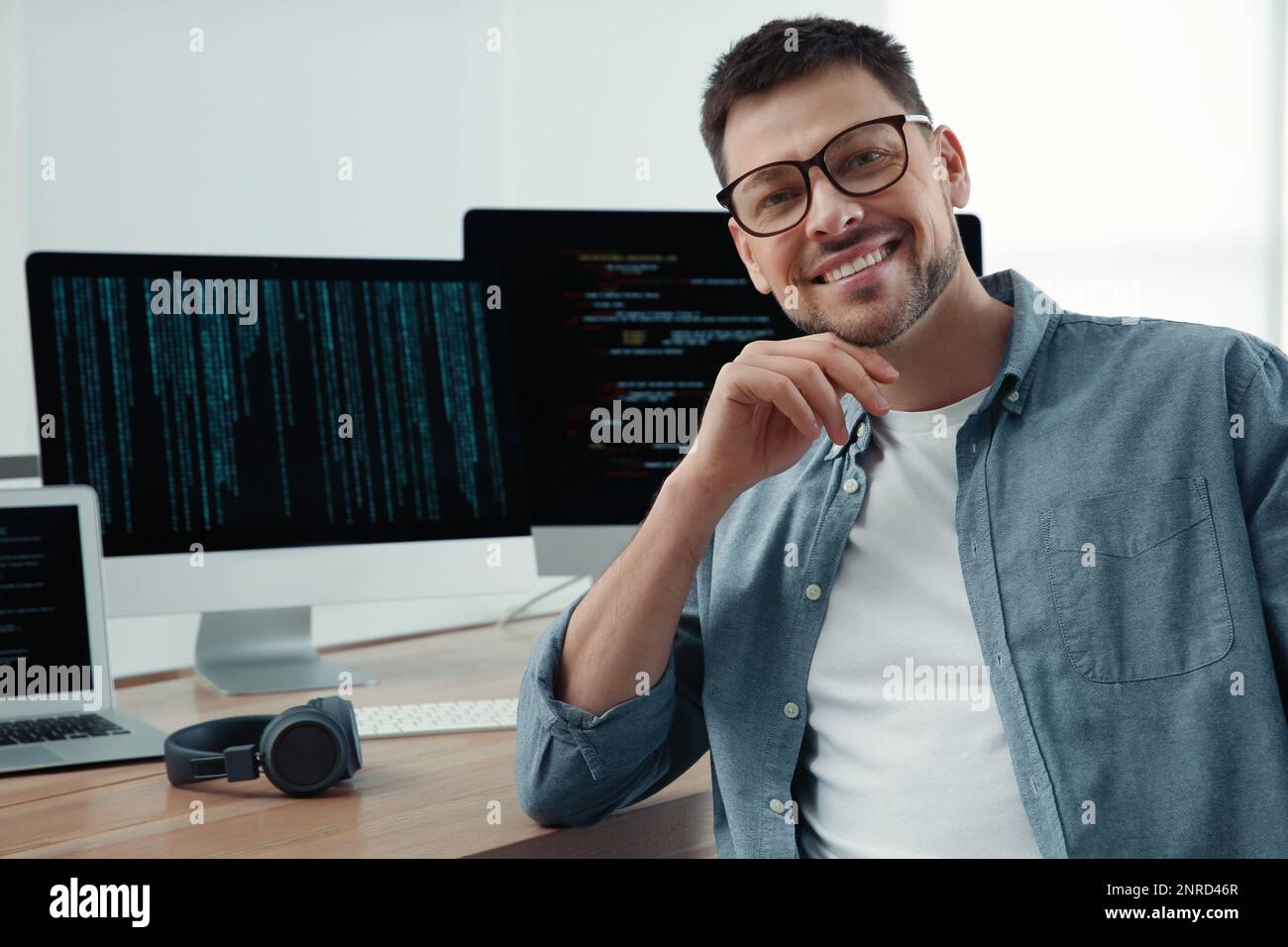 Happy programmer working at desk in office Stock Photo - Alamy