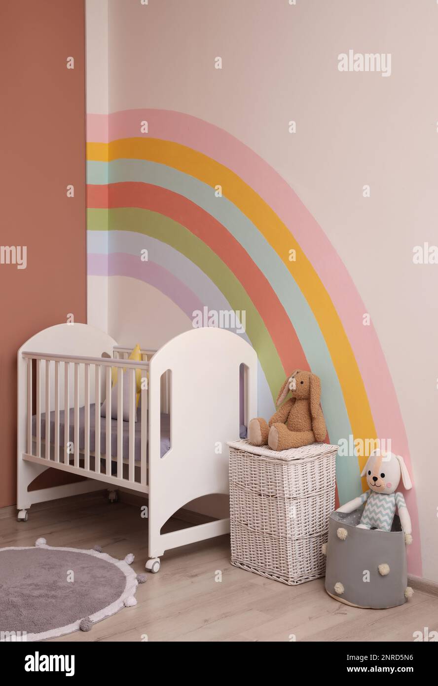 Cute child's room interior with beautiful rainbow painted on wall Stock Photo