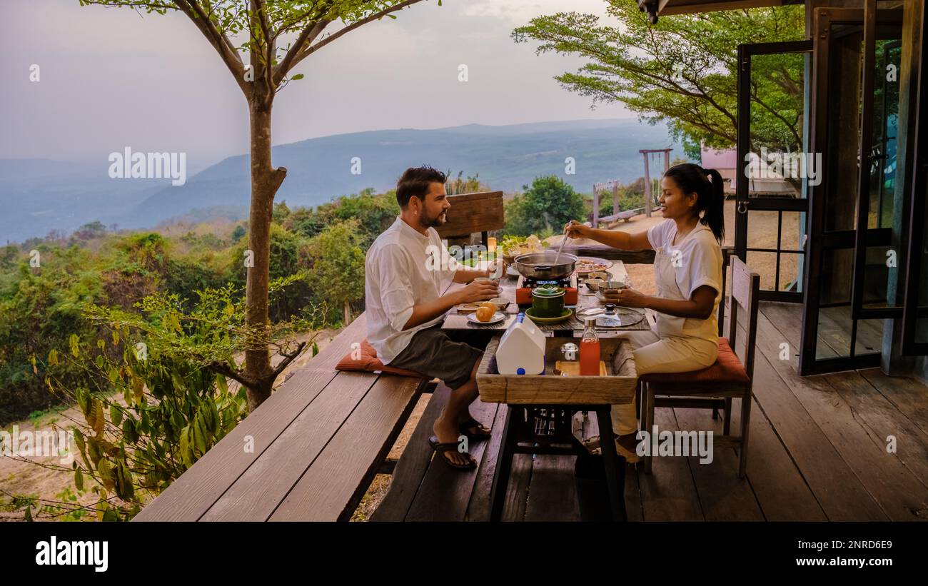 Thai Barbecue Buffet in the mountains on a tented camp, Thai style Grilled Sliced pork Thai Barbeque. couple having dinner outside Stock Photo