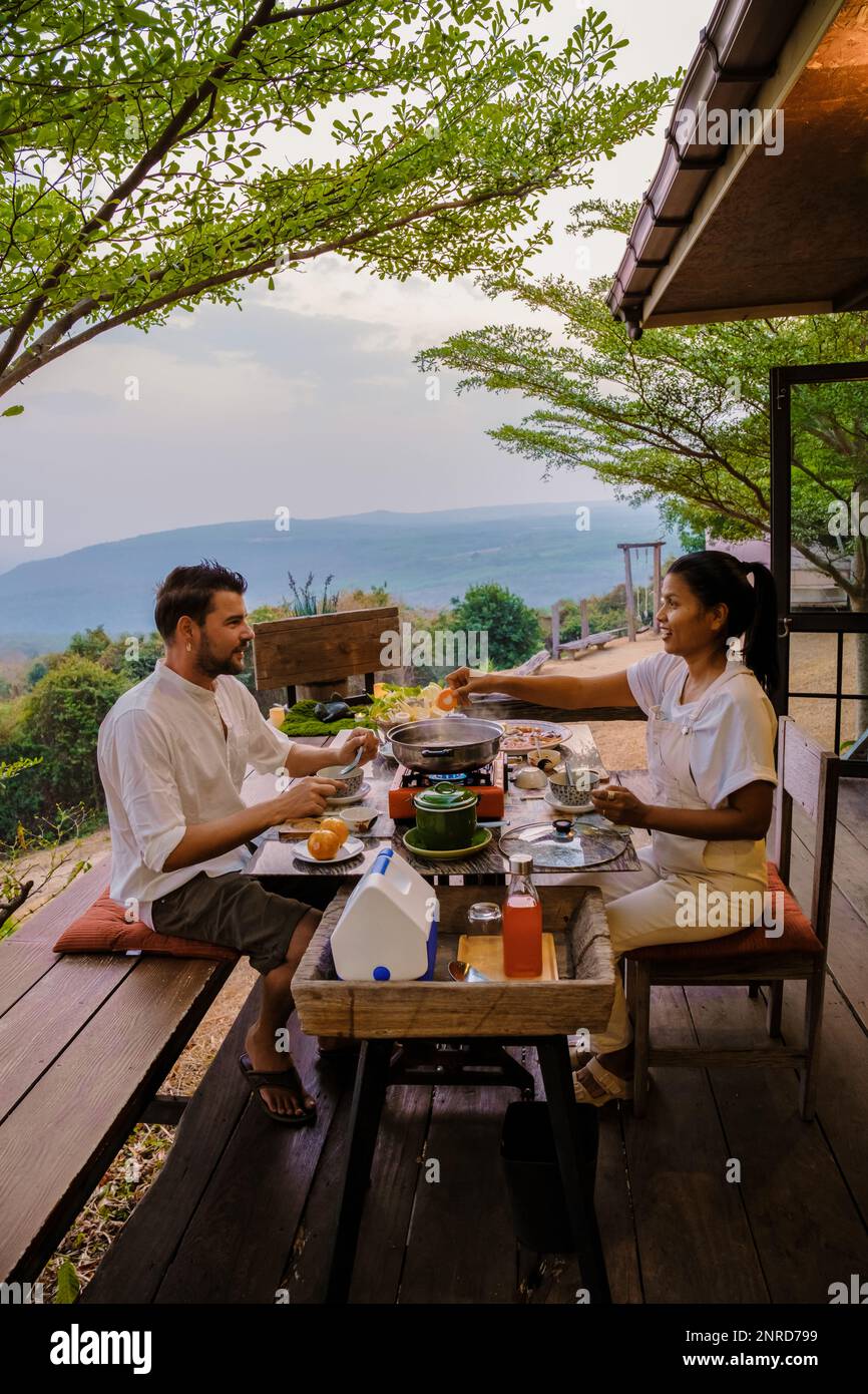 Thai Barbecue Buffet in the mountains on a tented camp, Thai style Grilled Sliced pork Thai Barbeque. couple having dinner outside Stock Photo