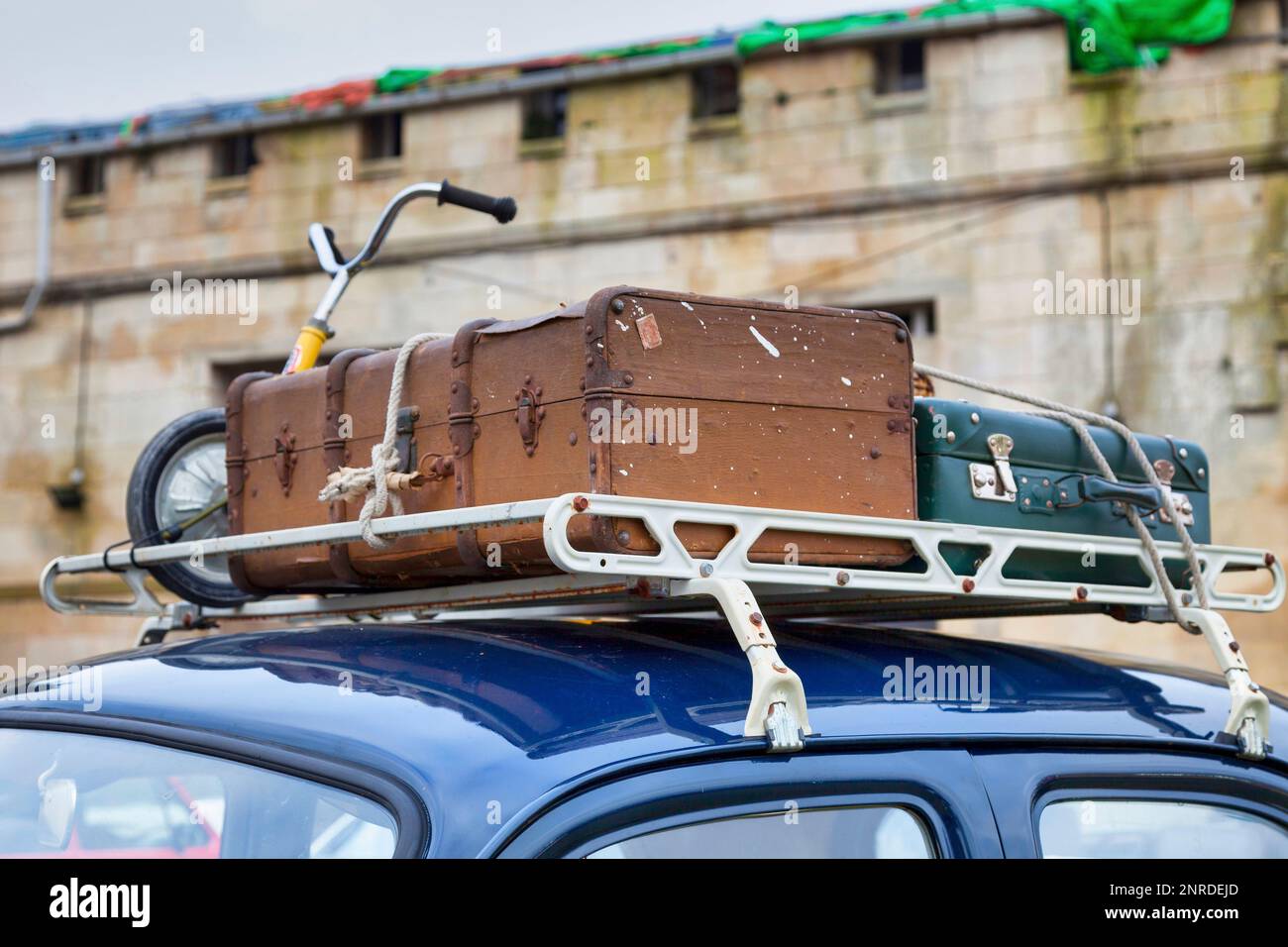 Old luggages atop of a navy blue Renault Frégate. Stock Photo