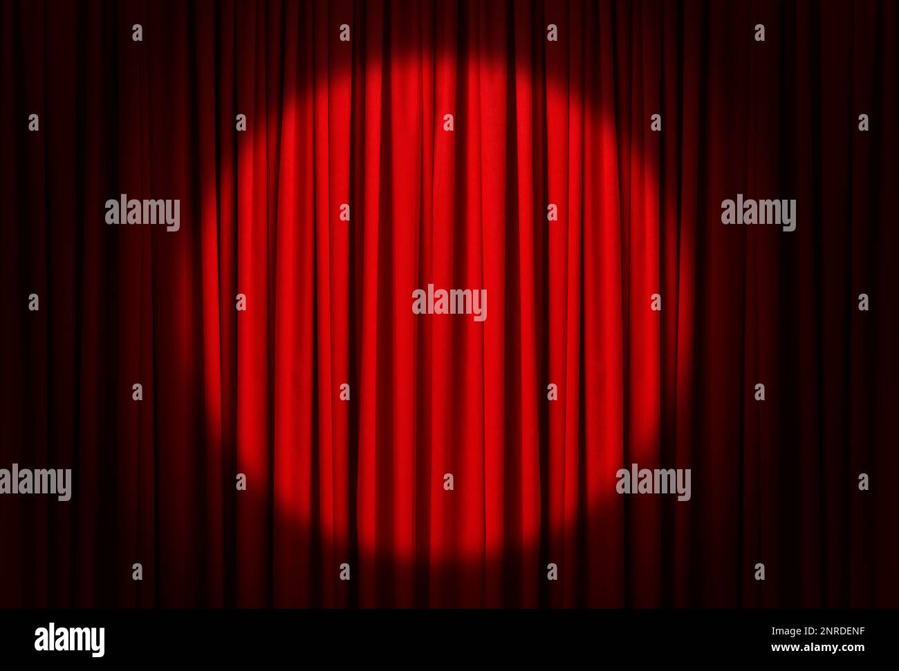 Spotlight illuminating closed red stage curtains. Start of performance Stock Photo