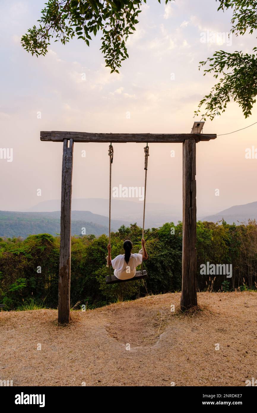 Asian women in a swing at Sunset at a mountain camping in Phitsanulok Thailand. luxury glamping Stock Photo Alamy