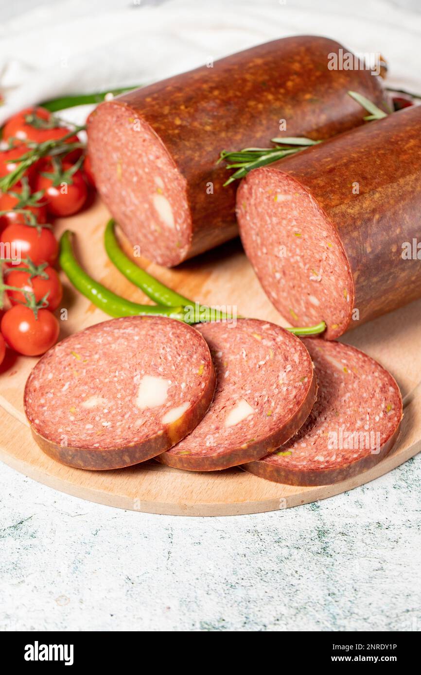 Beef sausage with cheddar. Raw grilled sausage on a wood serving board. Deli products. Close up Stock Photo