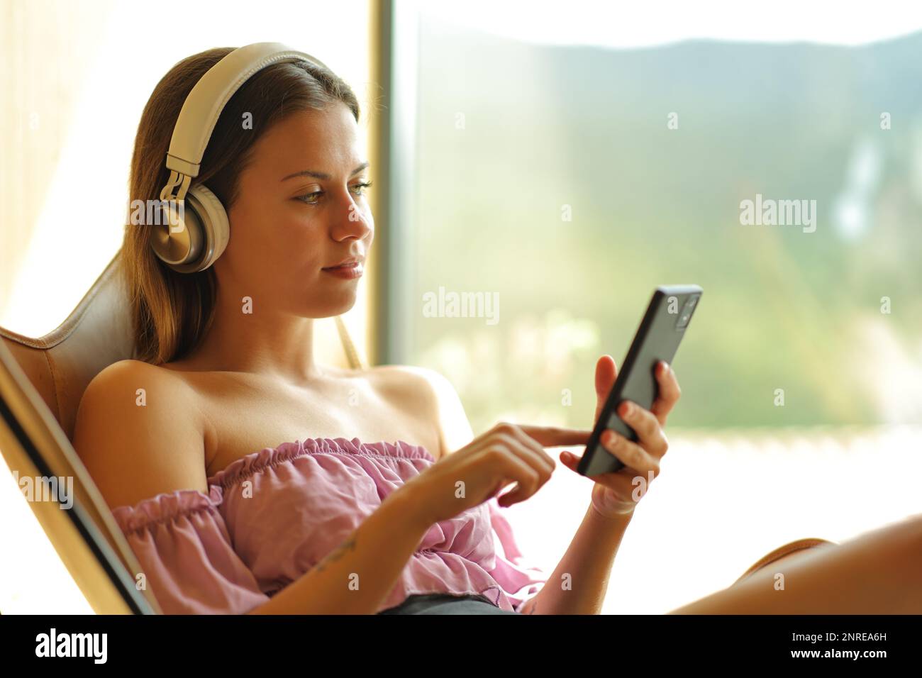 Teen listening to music sitting on a chair at home Stock Photo Alamy
