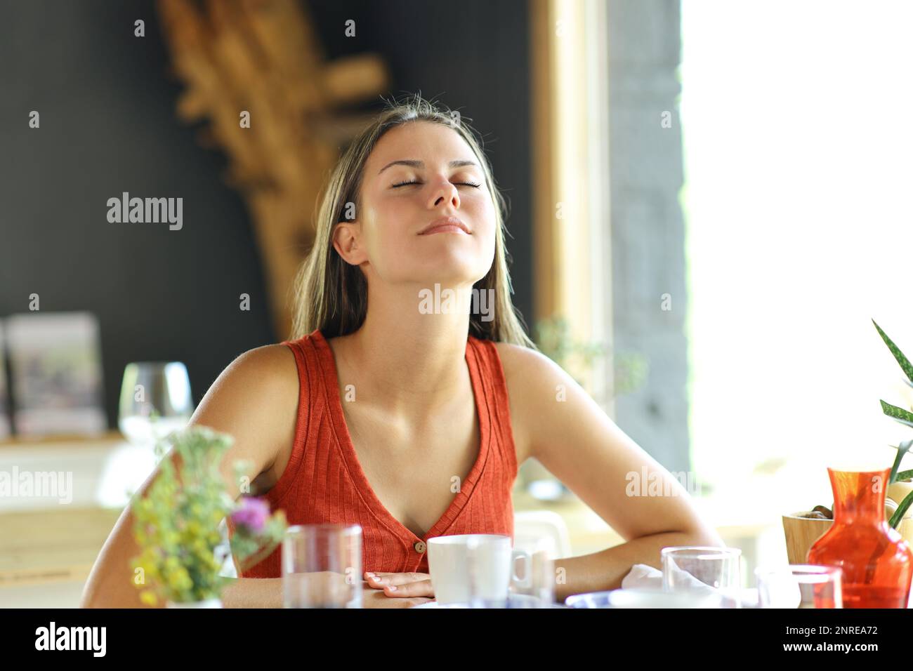 Happy woman in a restaurant breathing at breakfast Stock Photo