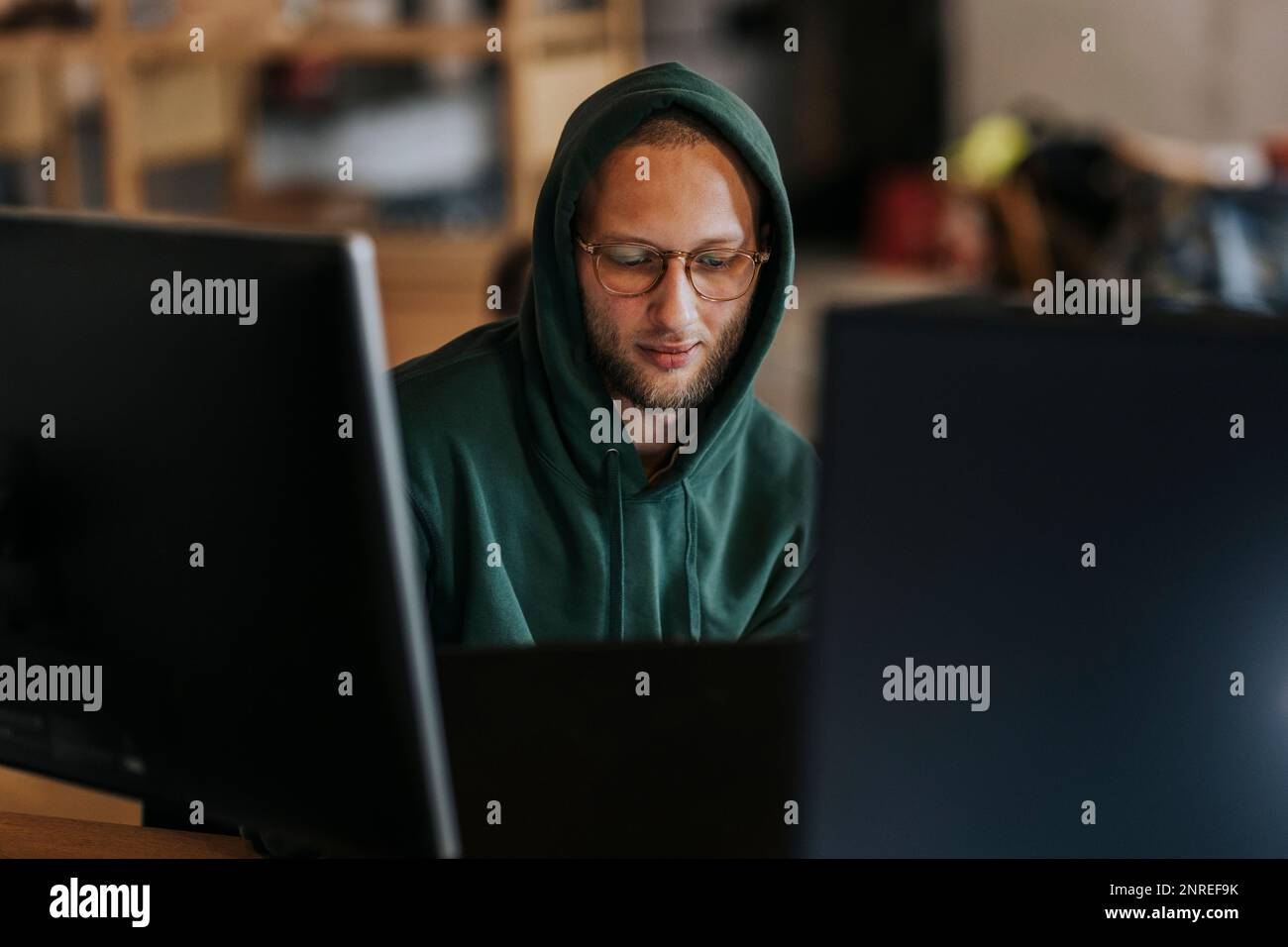 Male computer programmer working on laptop in creative office Stock Photo