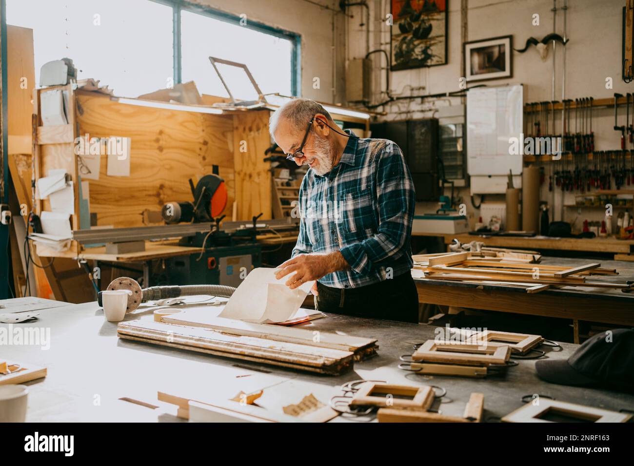 Craftsman examining documents at carpentry workshop Stock Photo