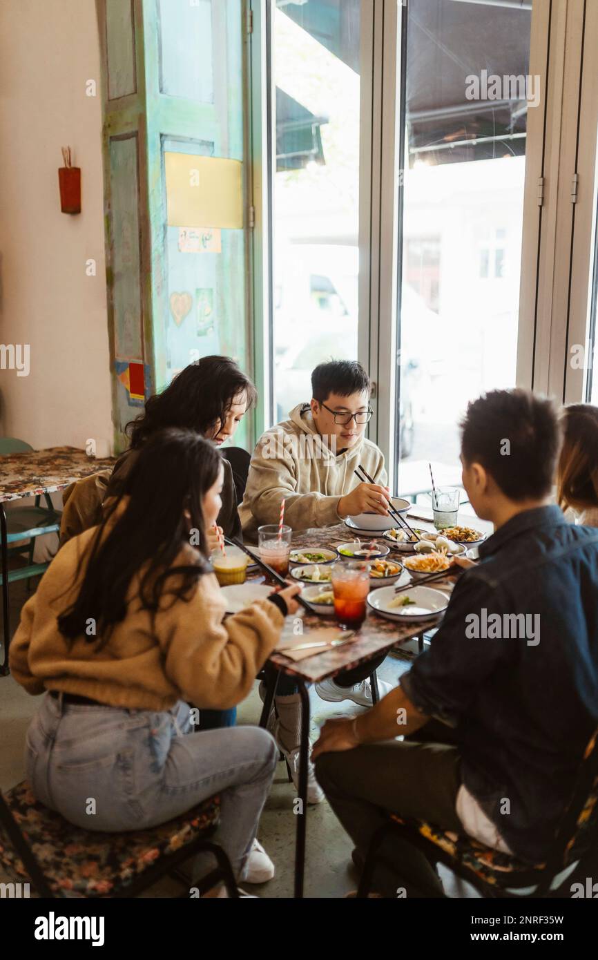 Male and female friends having lunch together at restaurant Stock Photo