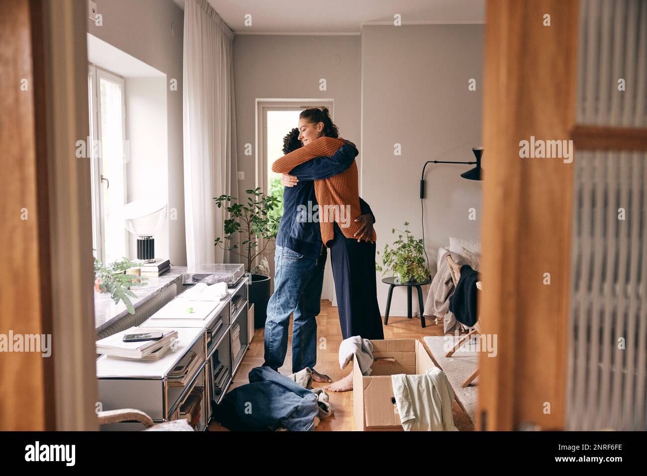Side view of couple embracing each other while standing at home Stock Photo