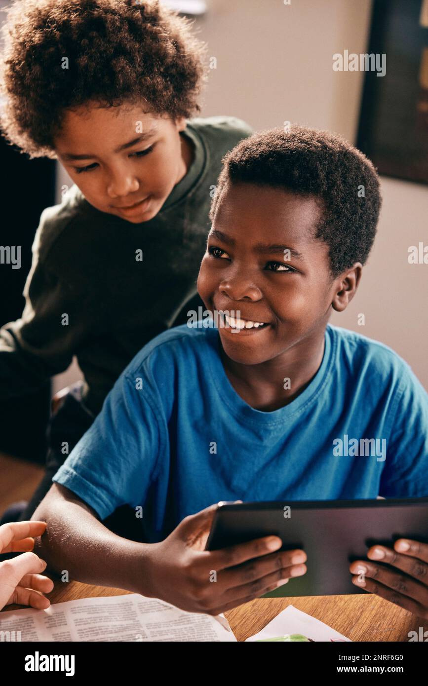 Happy brothers enjoying with digital tablet at home Stock Photo