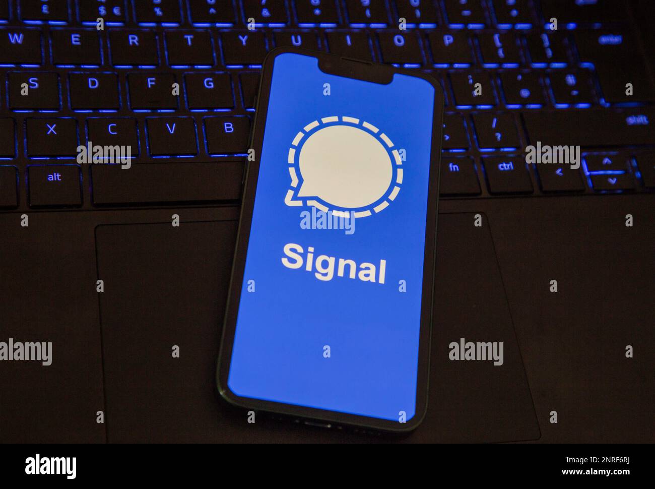 iPhone with Signal app loading screen sitting on an illuminated