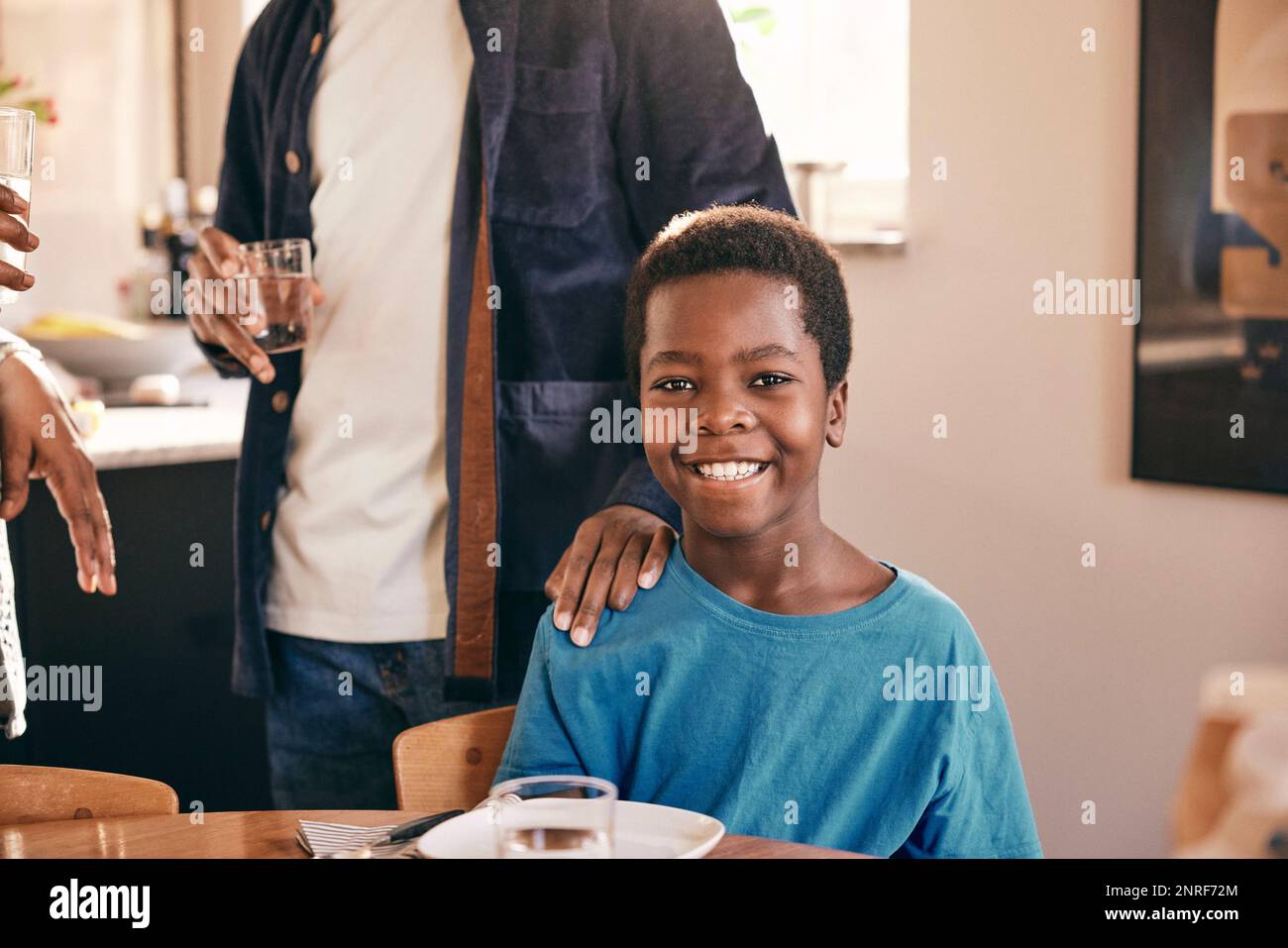 Portrait of happy boy with father keeping hand on shoulder at home Stock Photo
