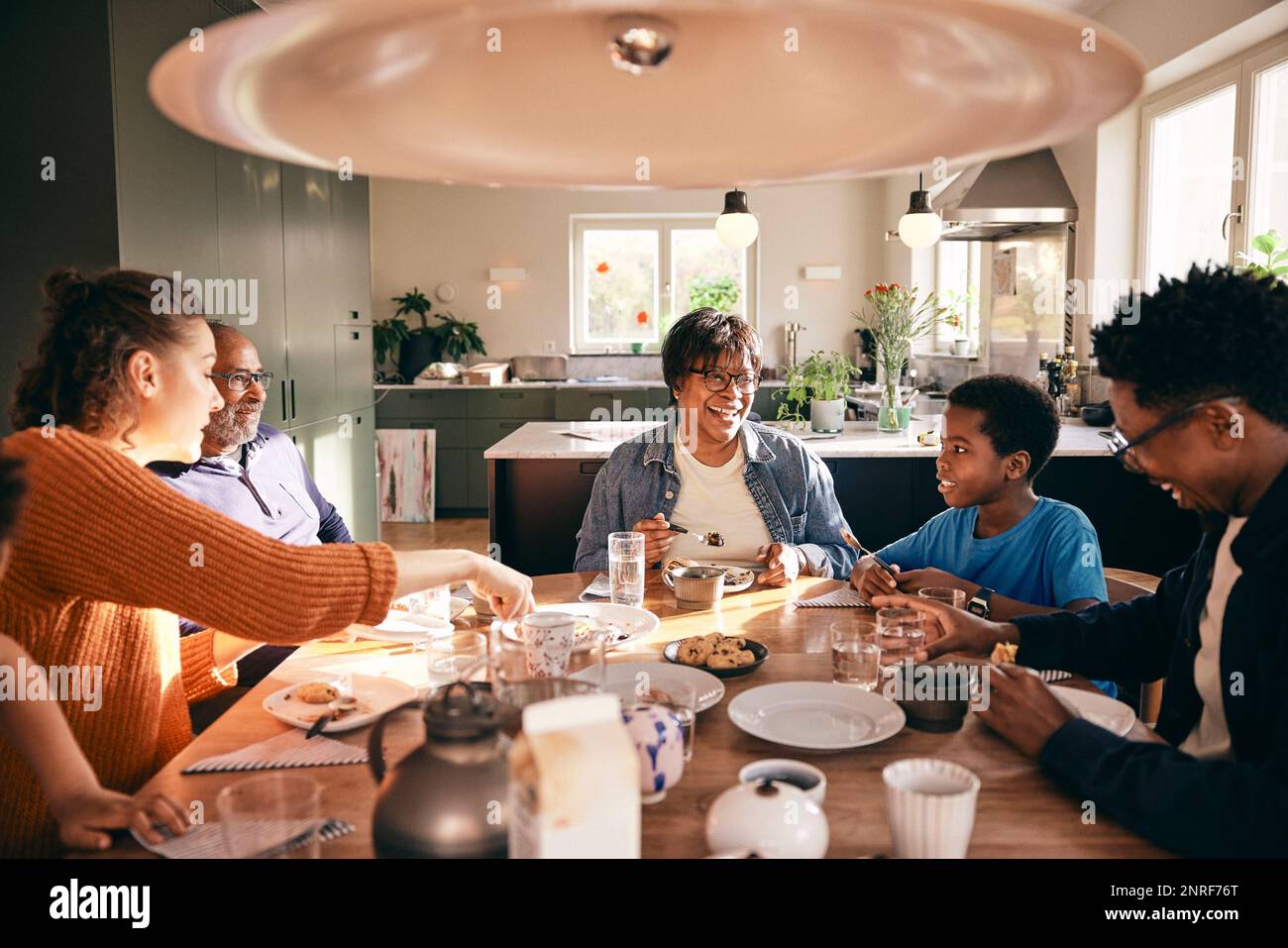 Multiracial family enjoying having food with each other at home Stock Photo