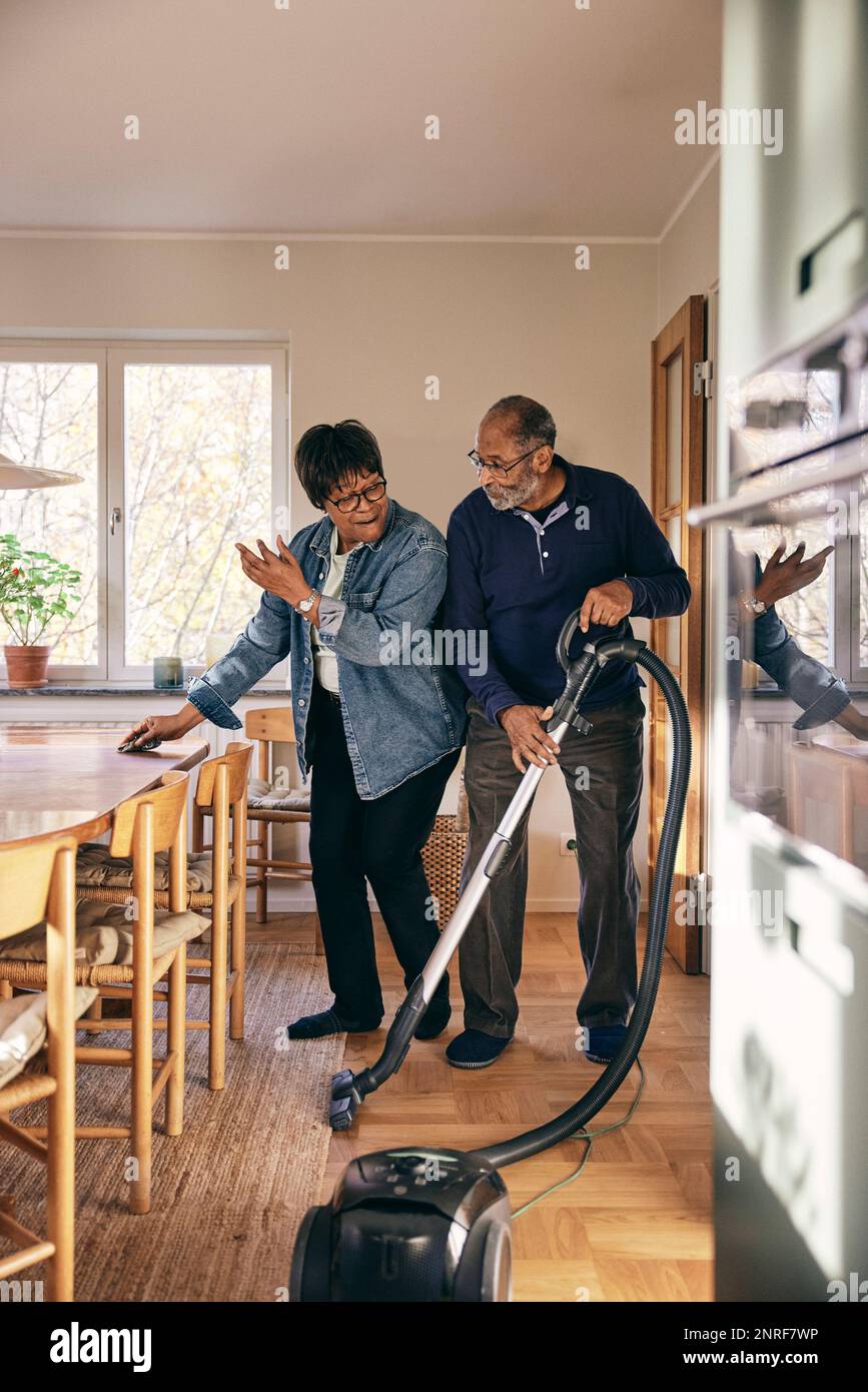Senior couple having fun while cleaning home Stock Photo