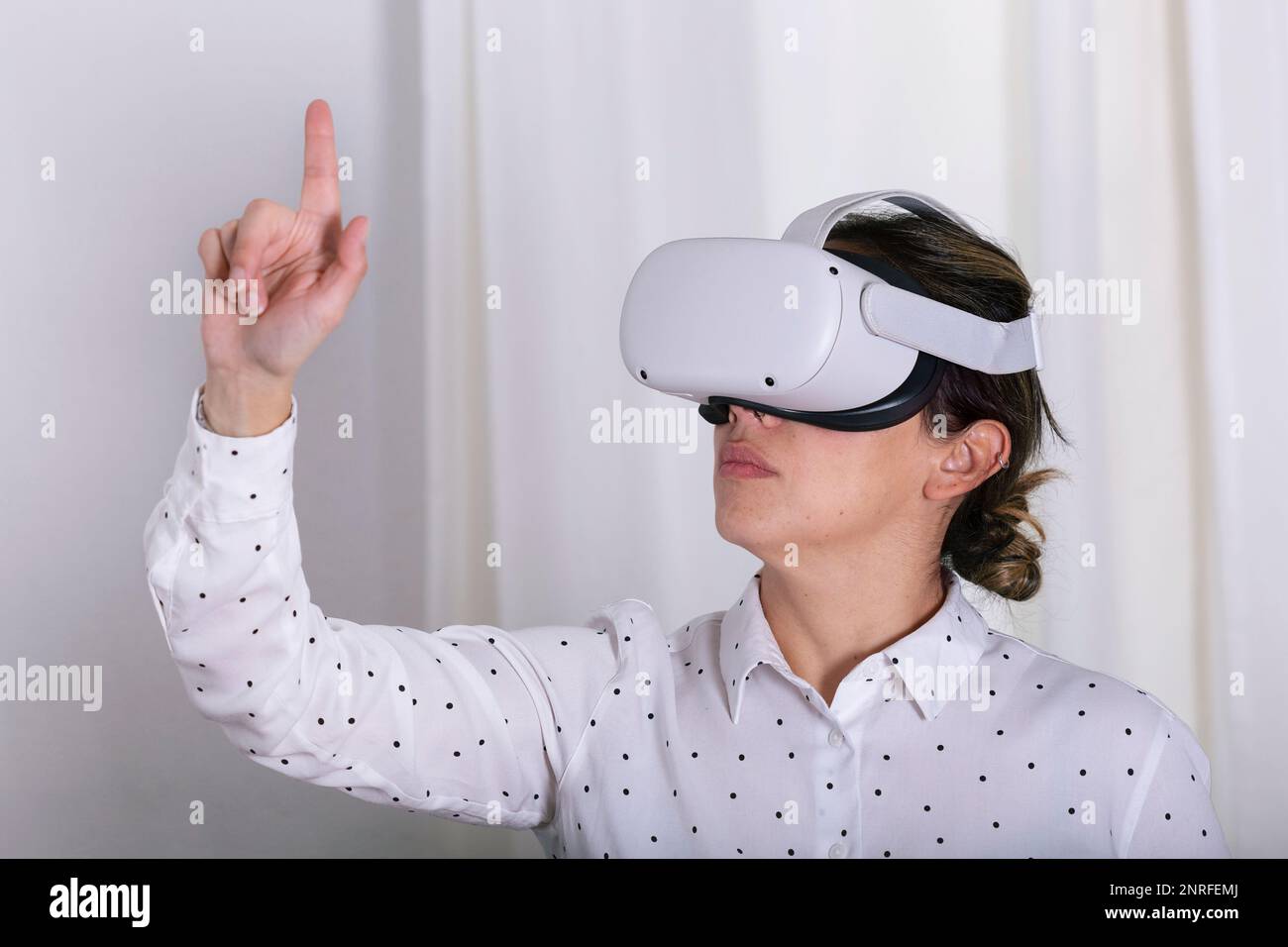 Young woman gesturing in virtual reality headset. Stock Photo