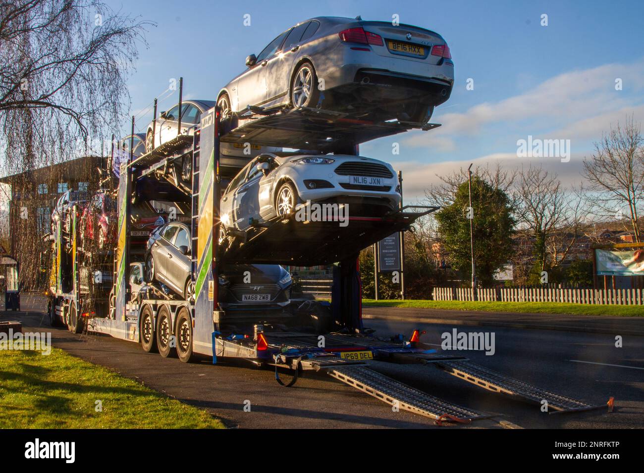 Motor Trade delivery vehicles unloading second-hand cars in Preston, UK Stock Photo