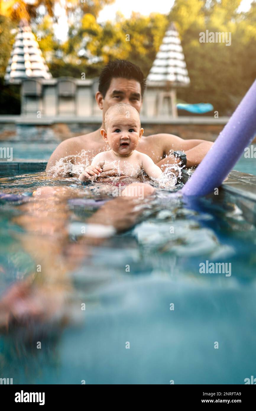 Dad holding baby in the pool Stock Photo Alamy
