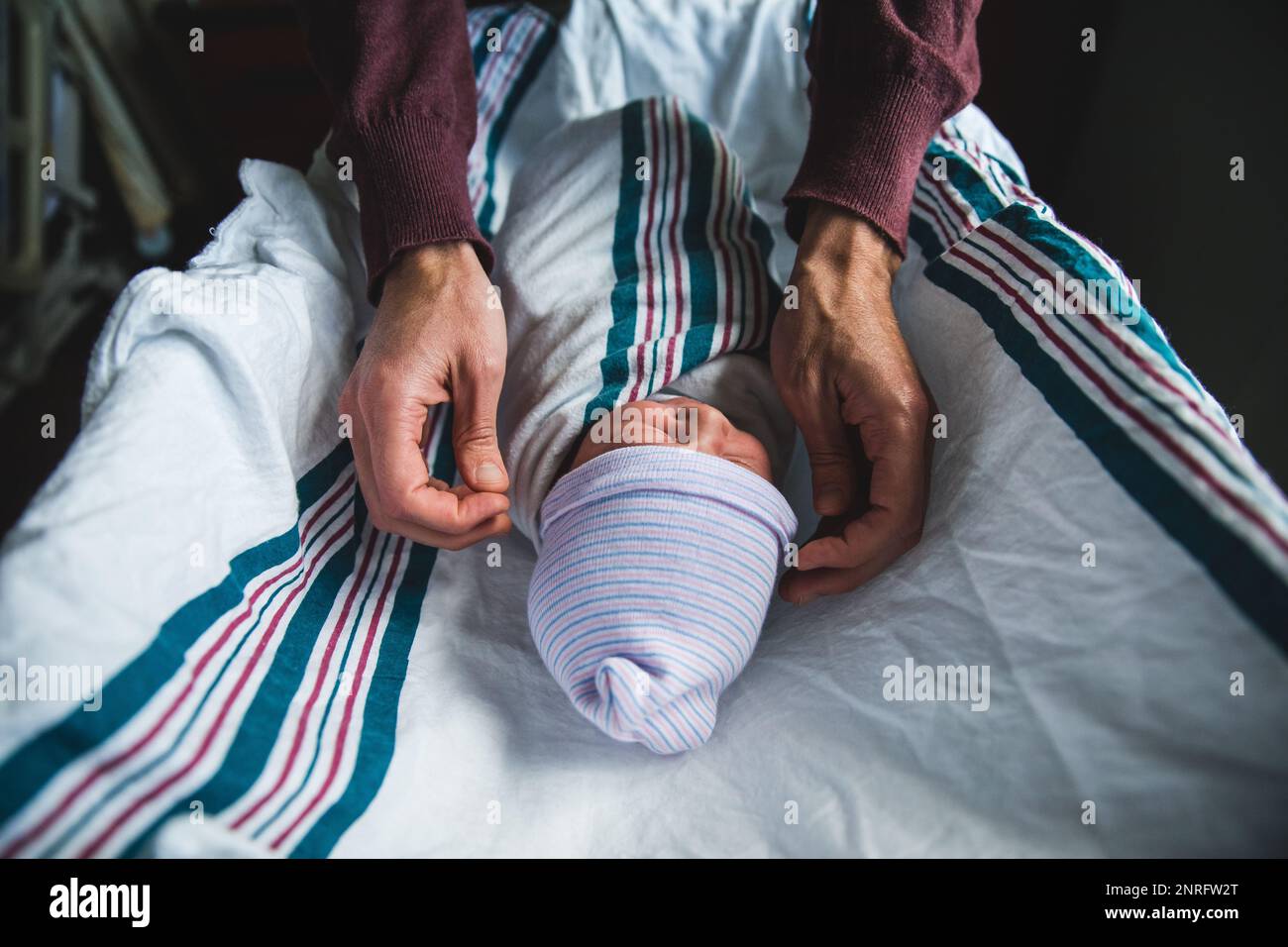 Adult fixing newborn baby's hat in hospital Stock Photo Alamy