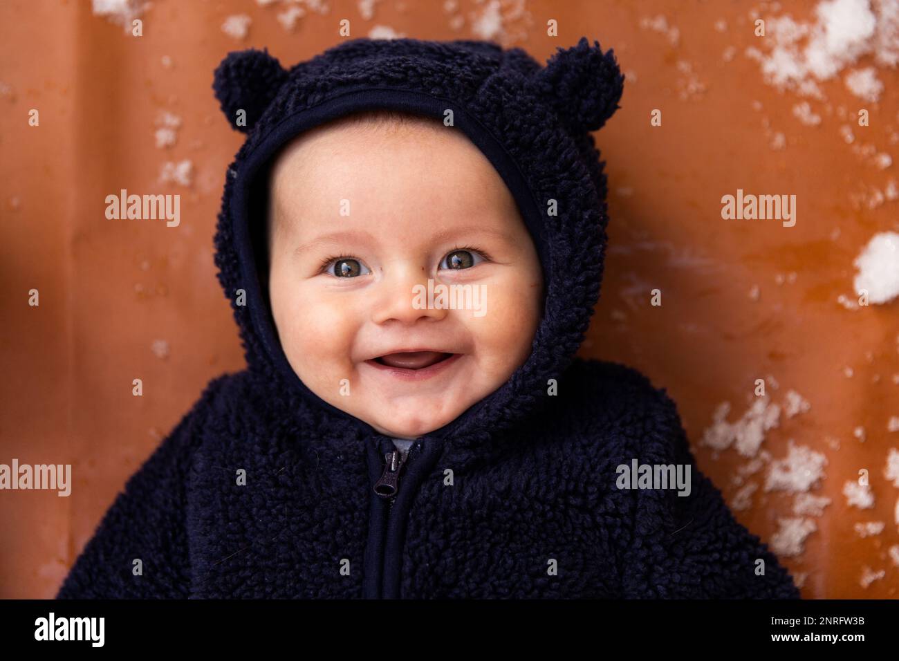 Happy baby smiling in the snow Stock Photo