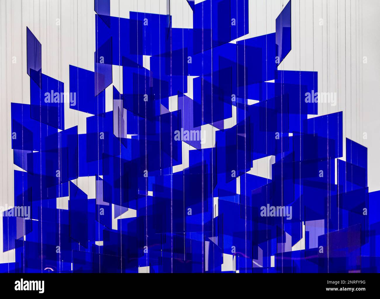 Full frame abstract background showing lots of hanging blue glass sheets in light back Stock