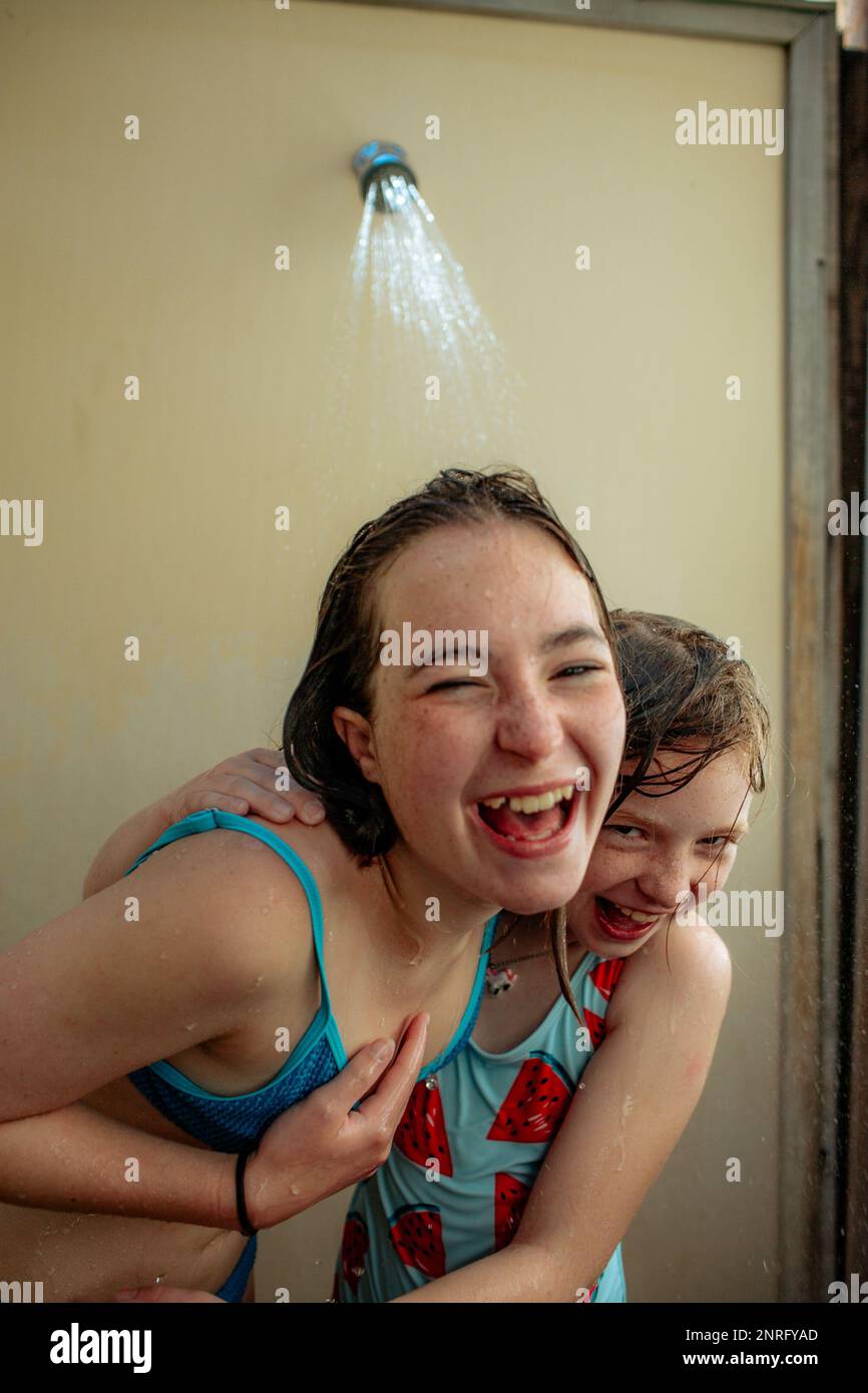 Happy sisters laughing in outdoor shower after swimming Stock Photo Alamy