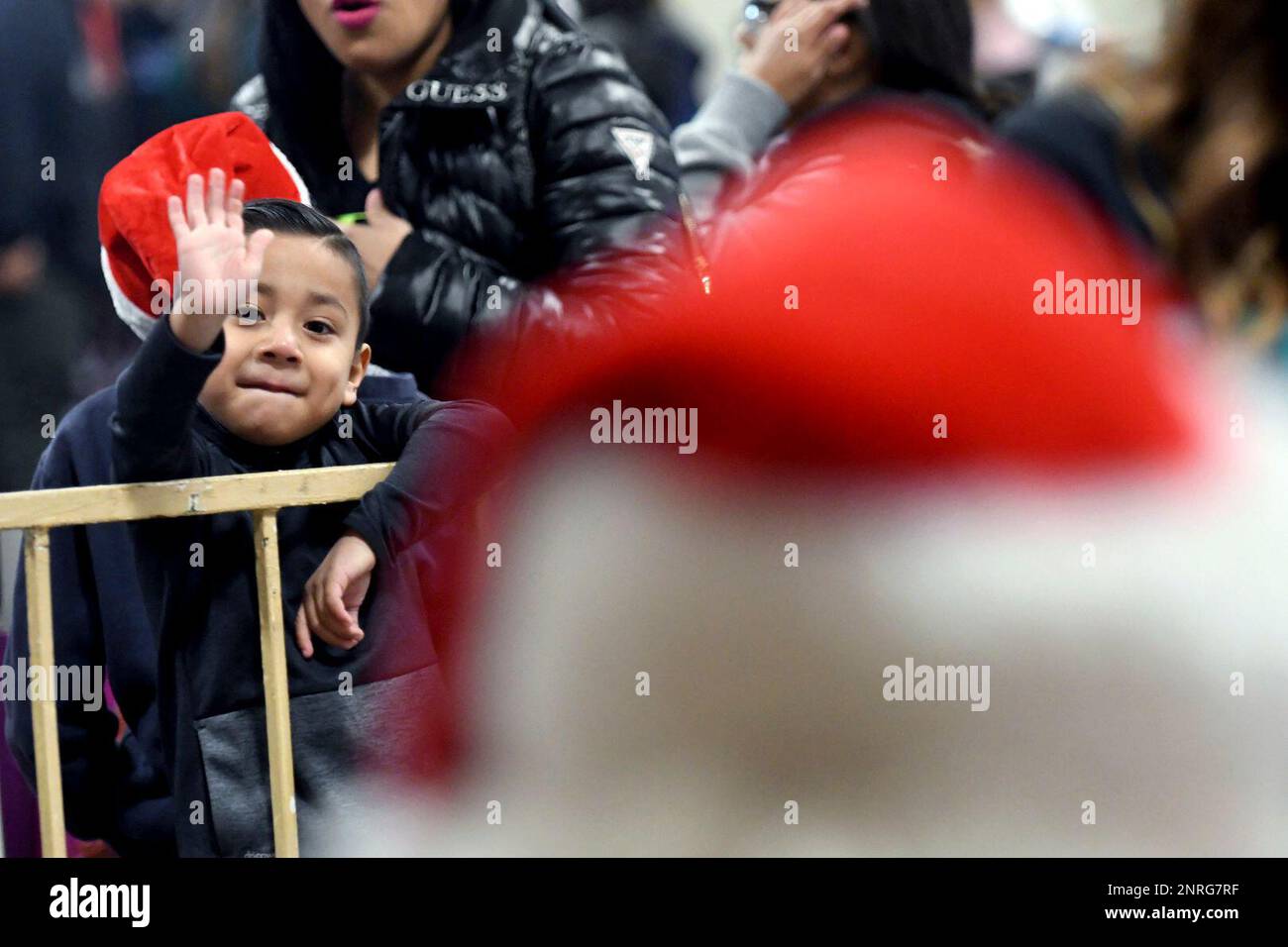 A boy waves at Santa Claus during the Victor Valley Rescue Mission's
