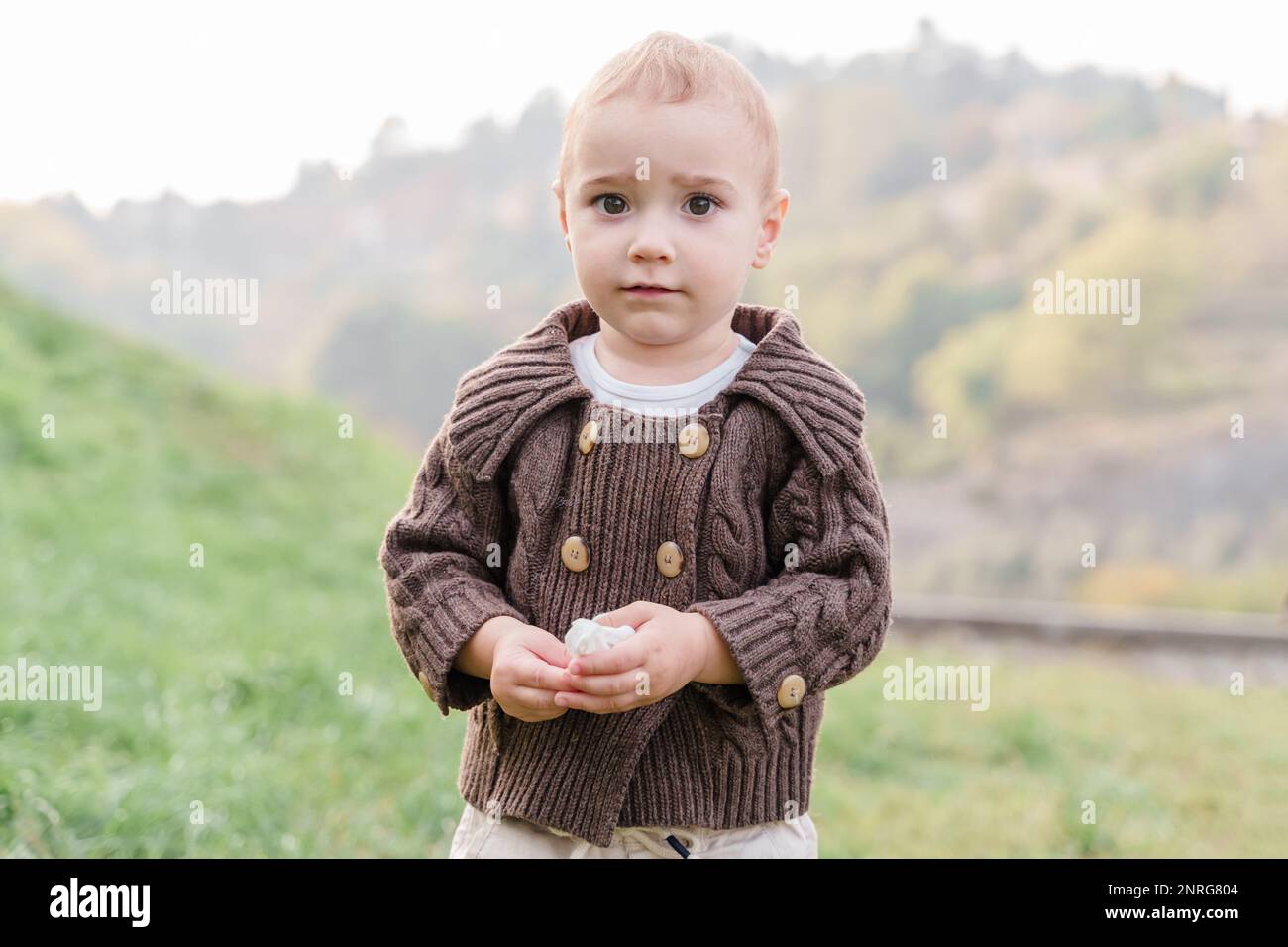 A brown-eyed Caucasian baby boy toddler outdoors Stock Photo
