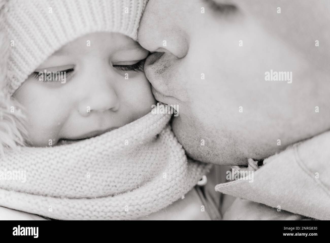 Close-up B&W portrait of a ruddy baby toddler and dad on a cold winter Stock Photo