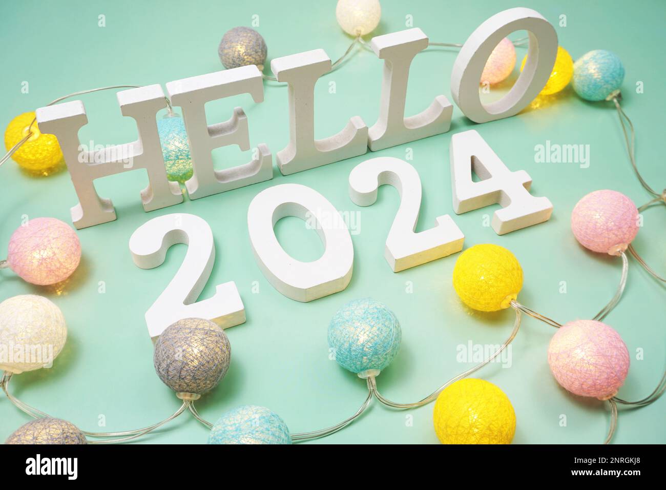 Hello 2024 alphabet letter with LED cotton balls on green background