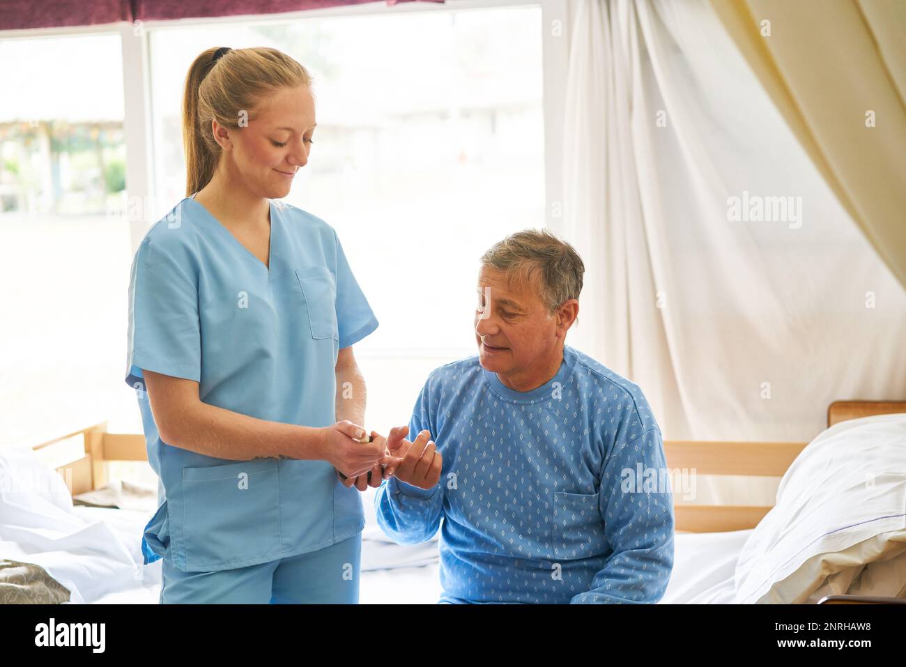 Smiling female nurse checking blood sugar on finger of diabetic elderly