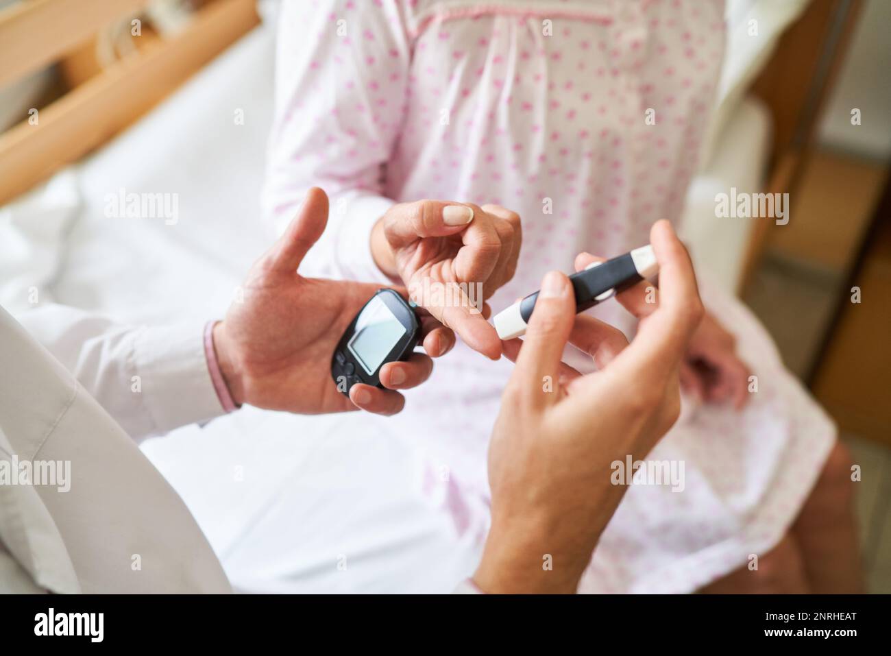 Closeup of male nurse checking blood sugar on finger of diabetic