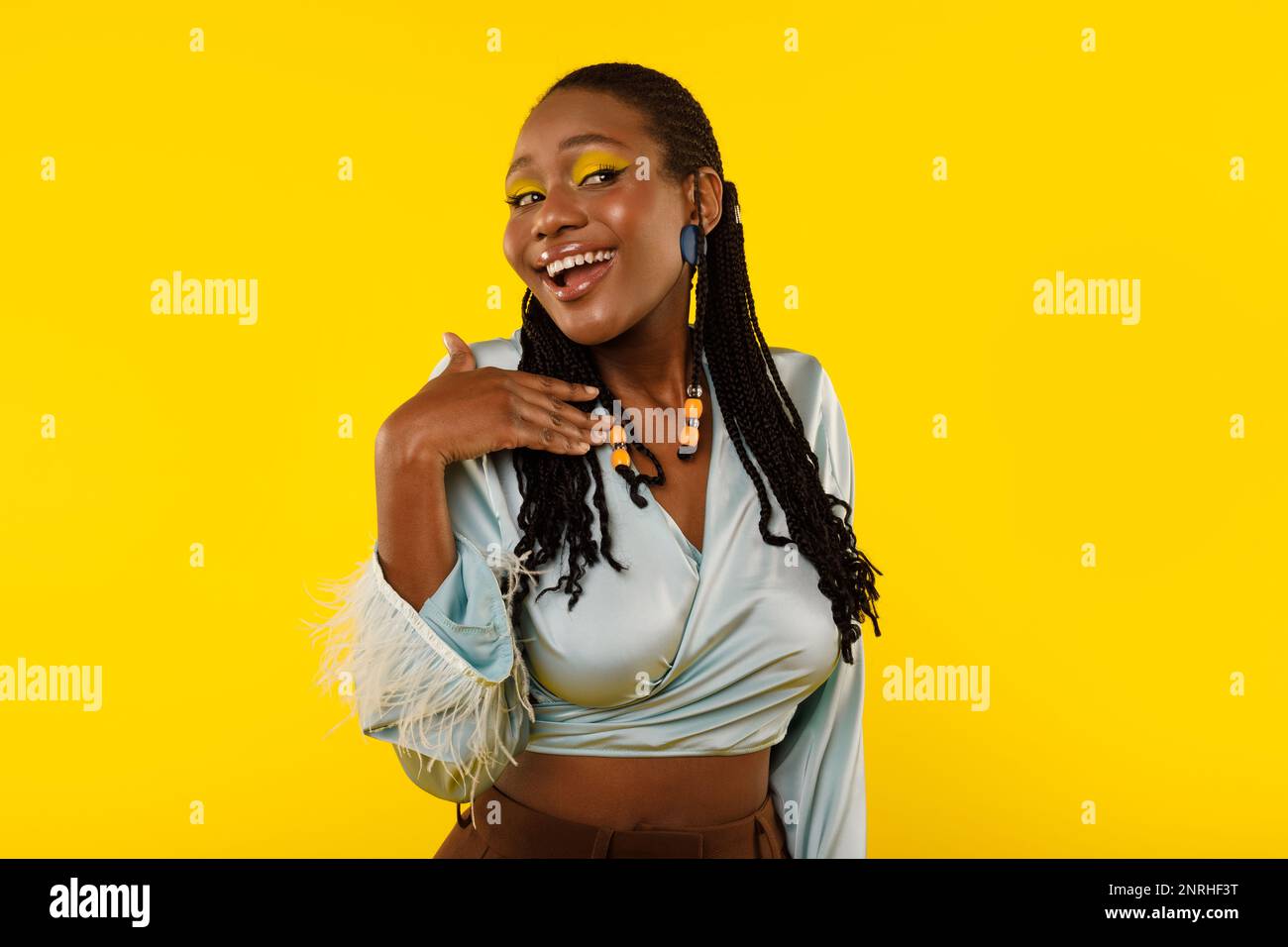 Gorgeous Black Woman With Bright Makeup Posing On Yellow Background Stock Photo