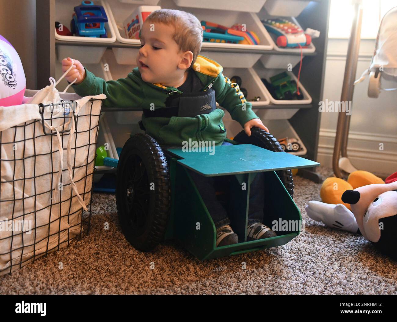 Brody Moreland, 2, reaches for his toys while in his GoBro, a wheelchair  his parents designed for him, Oct. 15 at his home in Centralia, Missouri.  Brody uses a larger wheelchair when