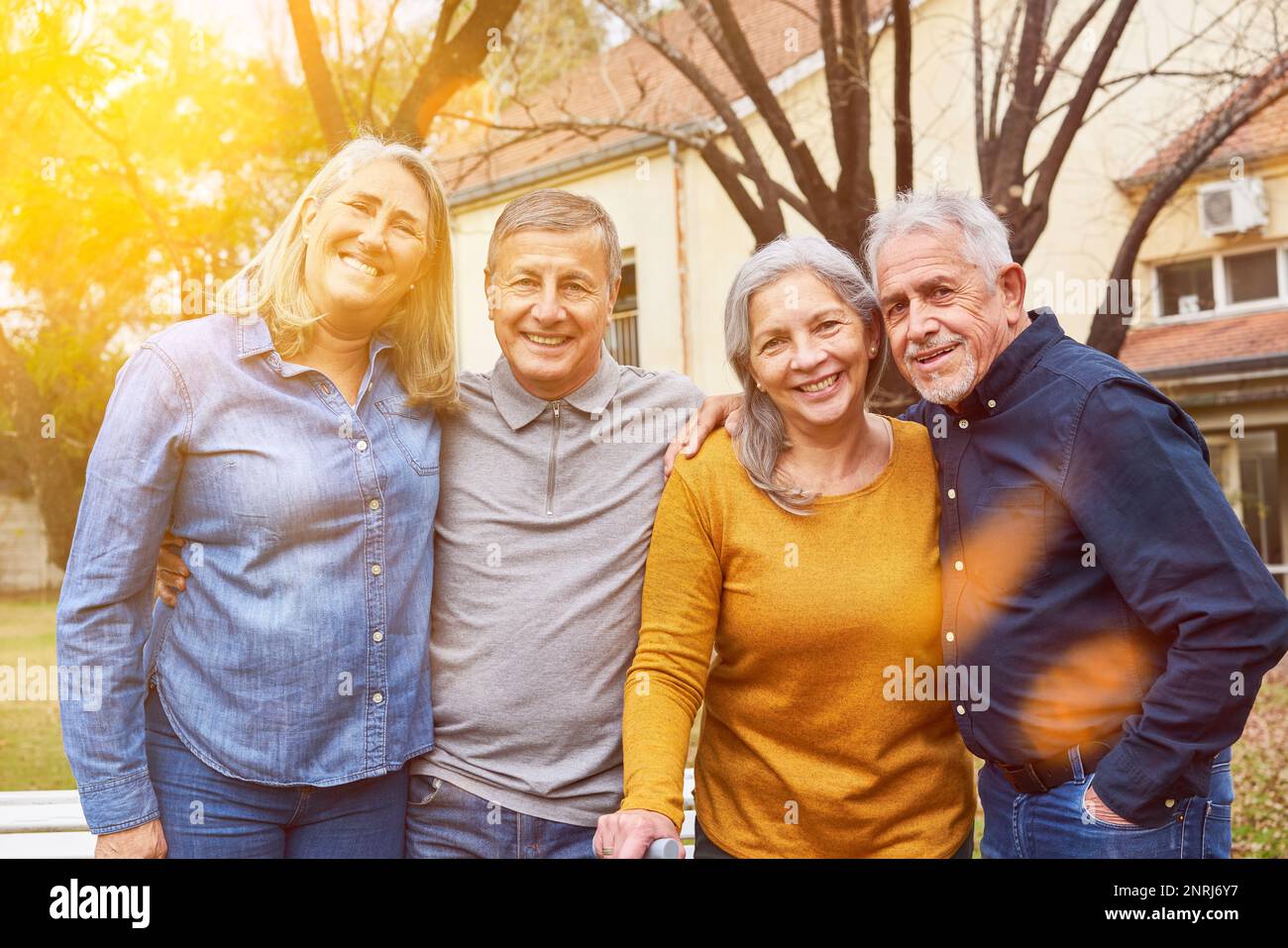 Two happy senior couples as friends group smiling in garden of nursing home Stock Photo