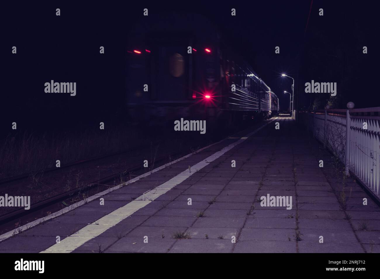 Late train going away in night from small countryside station Stock
