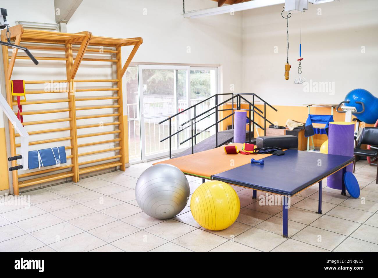 Interior of rehabilitation center with bed and various exercise equipment in room Stock Photo
