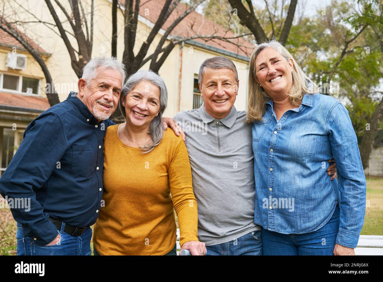 Group of two happy senior couples smiling in garden of nursing home Stock Photo